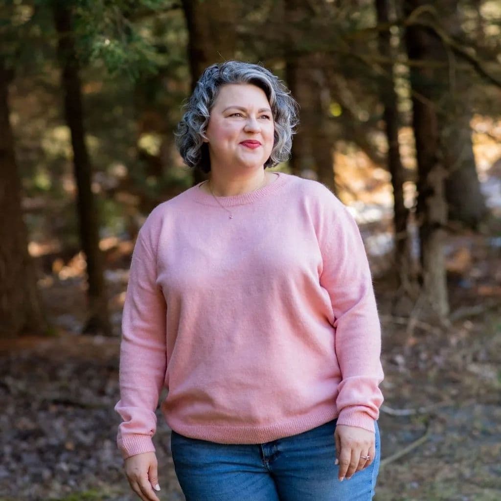 Heather, standing among evergreen trees